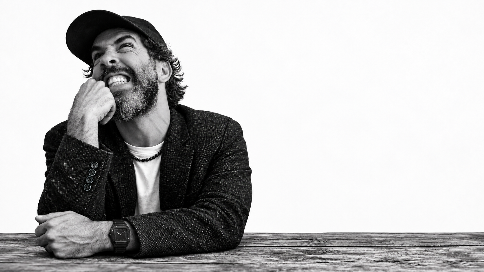 Amir Rouani smiling, seated at a wooden table